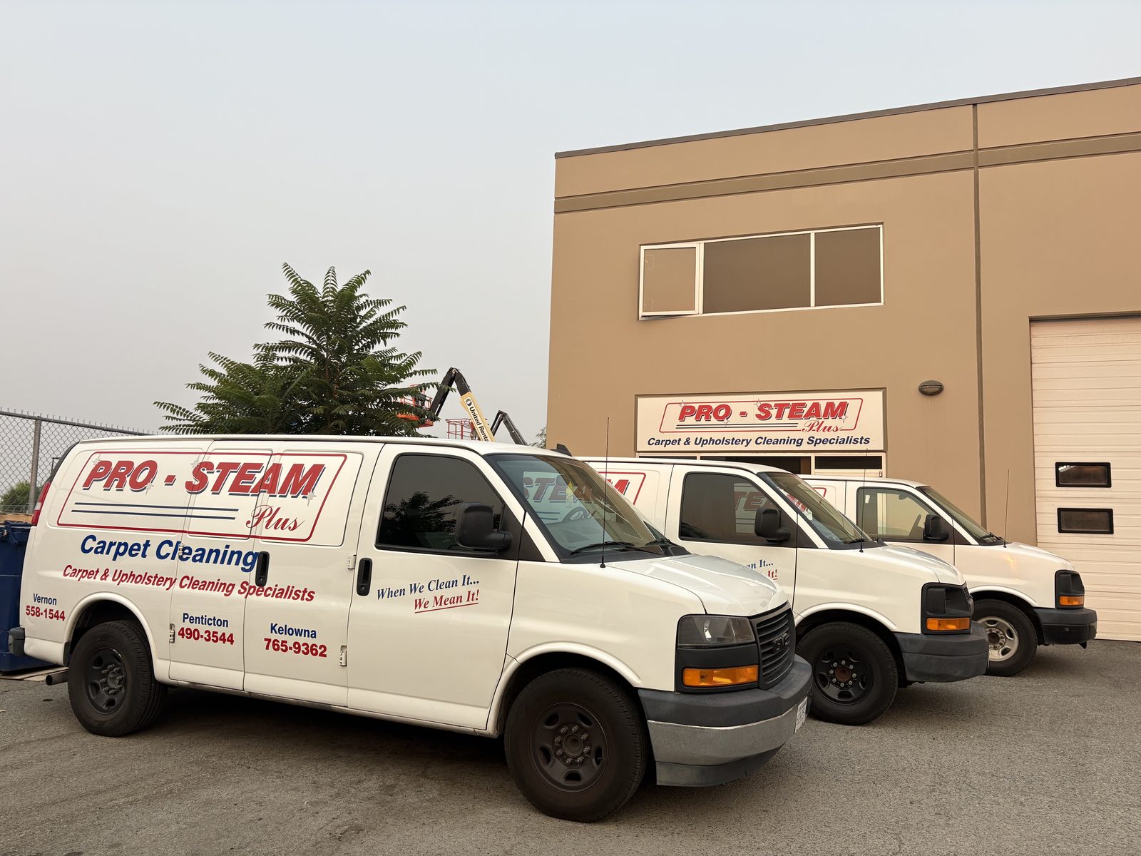 Pro-Steam Plus branded carpet cleaning vans parked outside the Kelowna office